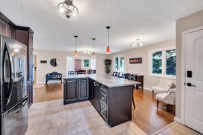 Enjoy cooking in this well-equipped kitchen with a large island, dining area, and window offering a view of the outdoors.