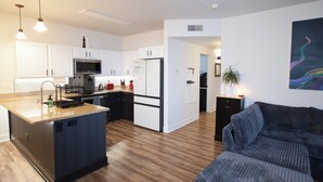 A modern kitchen with white cabinets, stainless steel appliances, and a wooden island. - Stylish 3-bed, 2-bath modern condo in Coeur d'Alene, perfect for up to 6 guests. Enjoy a fully equipped kitchen, king suite, and community steam sauna & gym. 12 mins from downtown CDA, 20 mins to Silverwood Theme Park, and 40 mins to Spokane! (Coeur d'Alene)