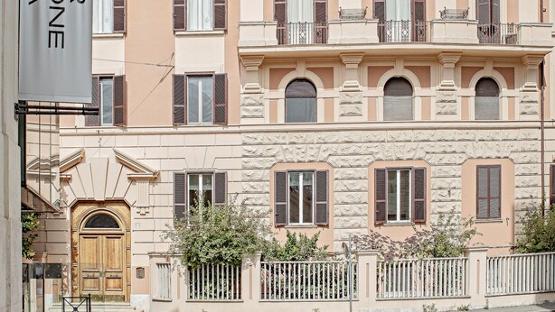A building with a beige facade, multiple balconies, and a wooden door. - At Manuela's Luxury Apartment  (Roma)