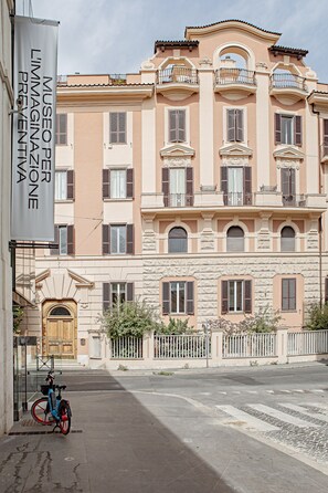 A building with a beige facade, multiple balconies, and a wooden door. - At Manuela's luxury apartment (Roma)