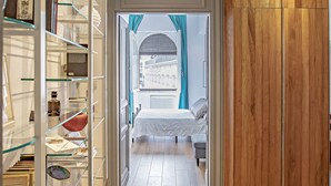 A hallway with a wooden floor, a glass shelving unit, and a wooden wardrobe. - At Manuela's Luxury Apartment  (Roma)
