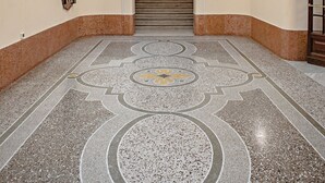 A spacious lobby with a high ceiling, a grand staircase, and a patterned floor. - At Manuela's Luxury Apartment  (Roma)