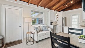 A compact living space with a kitchenette, a sofa, a dining table, and a wooden ceiling. - Tropical Oasis for your Naples Getaway!  (Naples)
