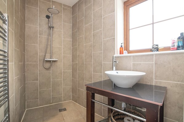 A bathroom with a shower, a sink, and a window. - St. John's Cottage (Shenstone)