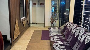 Un saló modern amb un sofà, una taula de centre i una làmpada decorativa al sostre.