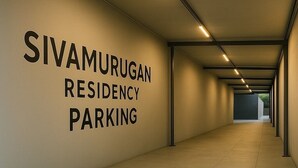 Un passadís amb un senyal que diu "SIVAMURUGAN RESIDENCY PARKING".