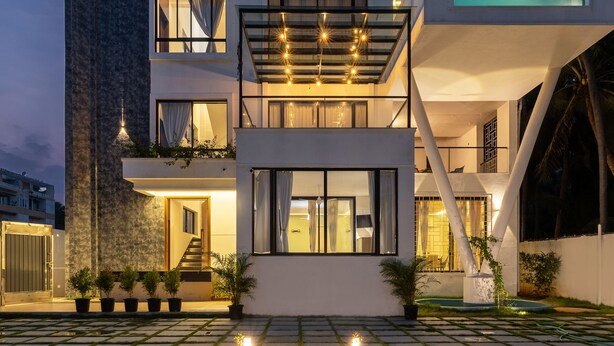 A modern two-story house with a glass balcony, a stone facade, and a well-lit entrance. - The Serene Shores - Luxury Private Villa (Vanur)