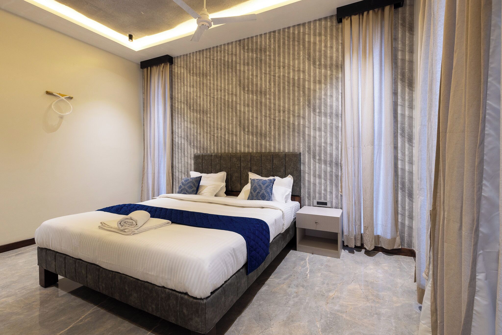 Ein modernes Hotelzimmer mit einem großen Bett, einem Nachttisch und einer Kopfteil.