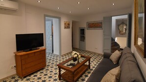 A living room with a television, wooden dresser, and a sofa. - Casa Los Anafes - in the heart of the village (Cómpeta)