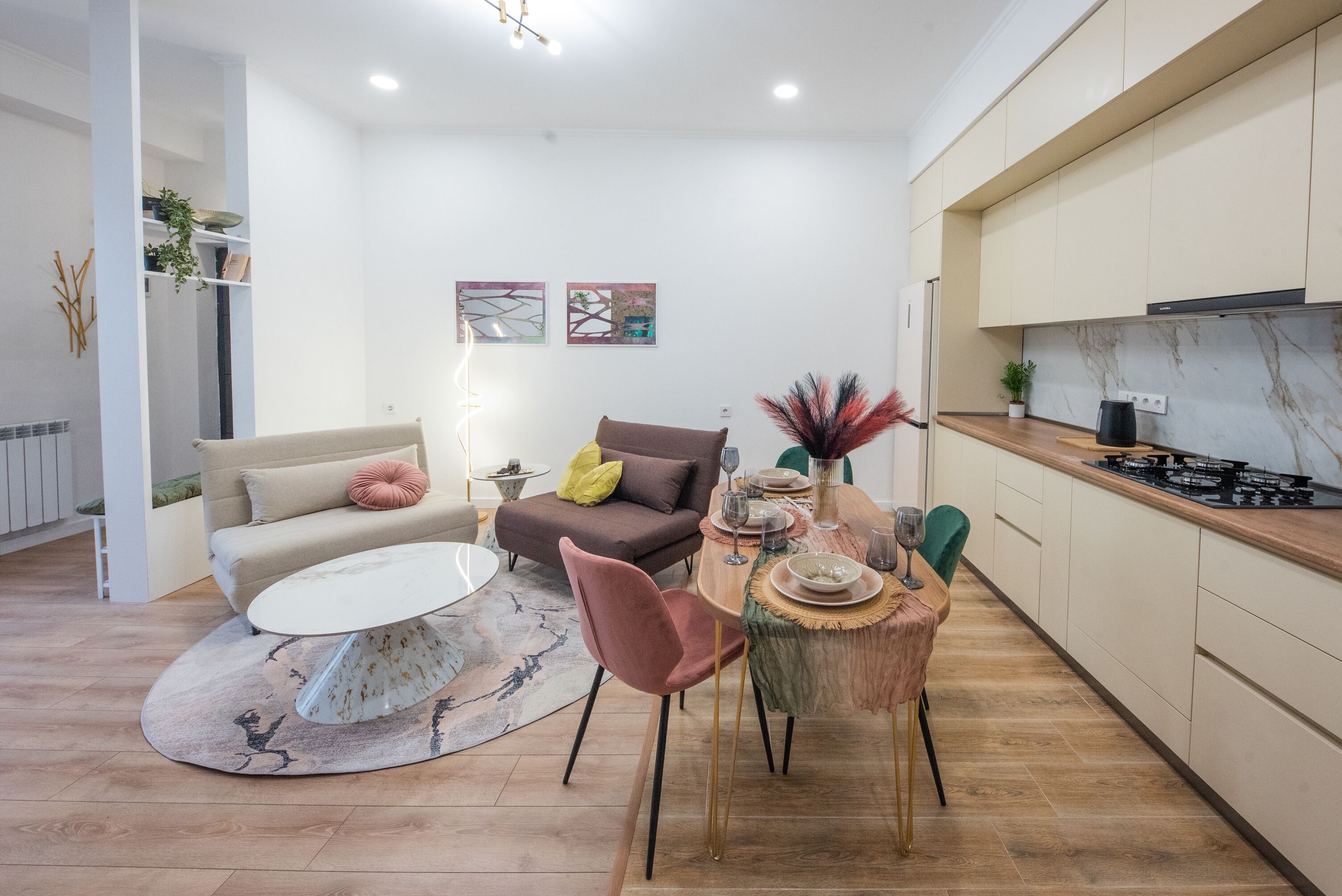 Un salon moderne avec une table ronde, un canapé et un coin repas avec des chaises.