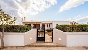 A modern two-story house with a gated entrance, a well-maintained lawn, and a clear sky. - Artemida Beachside Escape w BBQ Parking (Spata-Artemida)