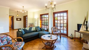 A living room with a sofa, chairs, a round table, and a TV. - Artemida Beachside Escape w BBQ Parking (Spata-Artemida)