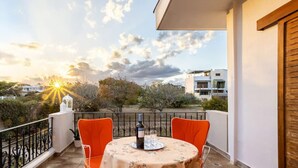 A balcony with a table set for two, overlooking a residential area with trees and buildings. - Artemida Beachside Escape w BBQ Parking (Spata-Artemida)