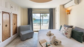 Ein Hotelzimmer mit Bett, Stuhl, Meerblick und Balkon.
