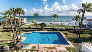 Ein Pool mit Blick auf den Ozean und Palmen.