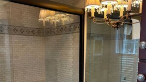 Ein Badezimmer mit großem Spiegel, Waschbecken und Dusche.