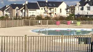 Et boligområde med huse, en swimmingpool og et træhegn.