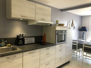 Enjoy meals in the kitchen with oven and coffee maker, and dine at the adjacent table and chairs.