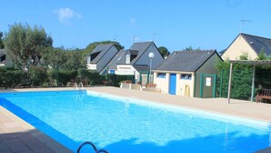 Une piscine à l’eau d’un bleu limpide, entourée d’une terrasse carrelée.