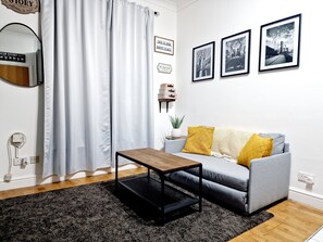 Relax in this stylish living room with a grey sofa, wooden coffee table, and black metal frame.