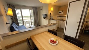 A hotel room with a dining area, kitchenette, and a seating area with a view. - 4-person apartment in Arzon, pool and parking, near beach and port (Arzon)