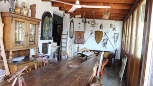 A rustic dining area with a wooden table, chairs, and a ceiling fan. - Nicolashouse on the sea 2 (Bari)
