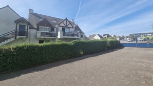 A residential area with houses, a paved driveway, and a clear sky. - T3 Duplex Apartment, 4 Pers, Sarzeau Center, Balcony (Sarzeau)
