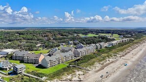 A coastal hotel with multiple buildings, a beach, and a golf course in the background. - Oceanfront OIBV 207 in Oak Island, NC: 3 beds, stunning beach views, sleeps 6! (Oak Island)