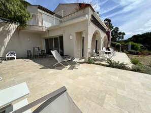 A modern house with a patio area featuring outdoor furniture and a stone floor. - Renovated villa near Gigaro beach, sea view, terrace (La Croix-Valmer)