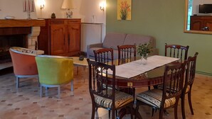 A dining area with a round table, chairs, and a chandelier. - Charming cottage with garden, WiFi, pets welcome (Thorigné-sur-Dué)