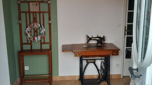 A room with a wooden chair, a sewing machine, and a wall with a 'Bienvenue' sign. - Charming cottage with garden, WiFi, pets welcome (Thorigné-sur-Dué)
