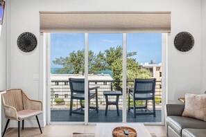 A balcony with a view of the sea, two chairs, a table, and a sofa. - Gulfside Sunset - 2309A   “Anna Maria Island” (Bradenton Beach)