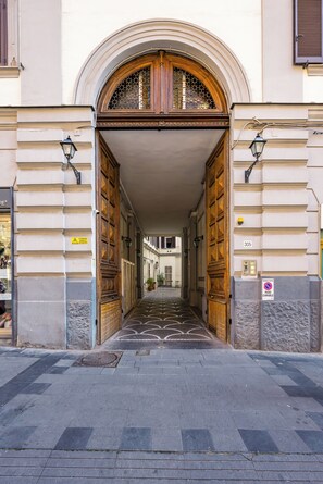 A building entrance with a wooden door, a tiled pathway, and a sign indicating a no parking zone. - Apartment Maison Pochet (Naples)