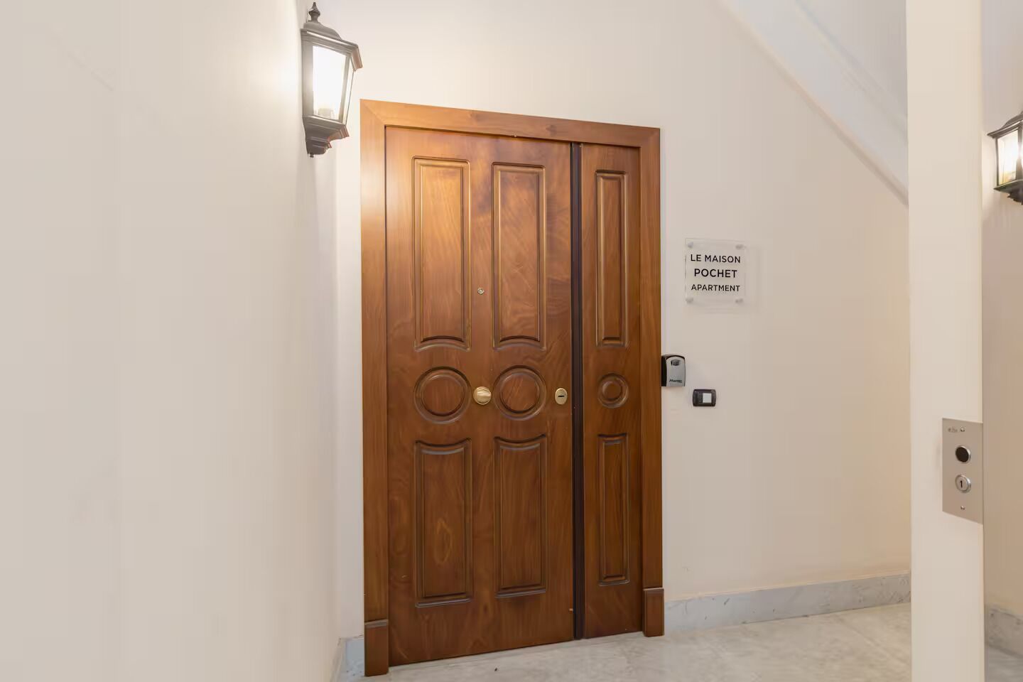 Una porta doppia in legno con un cartello che indica un appartamento.