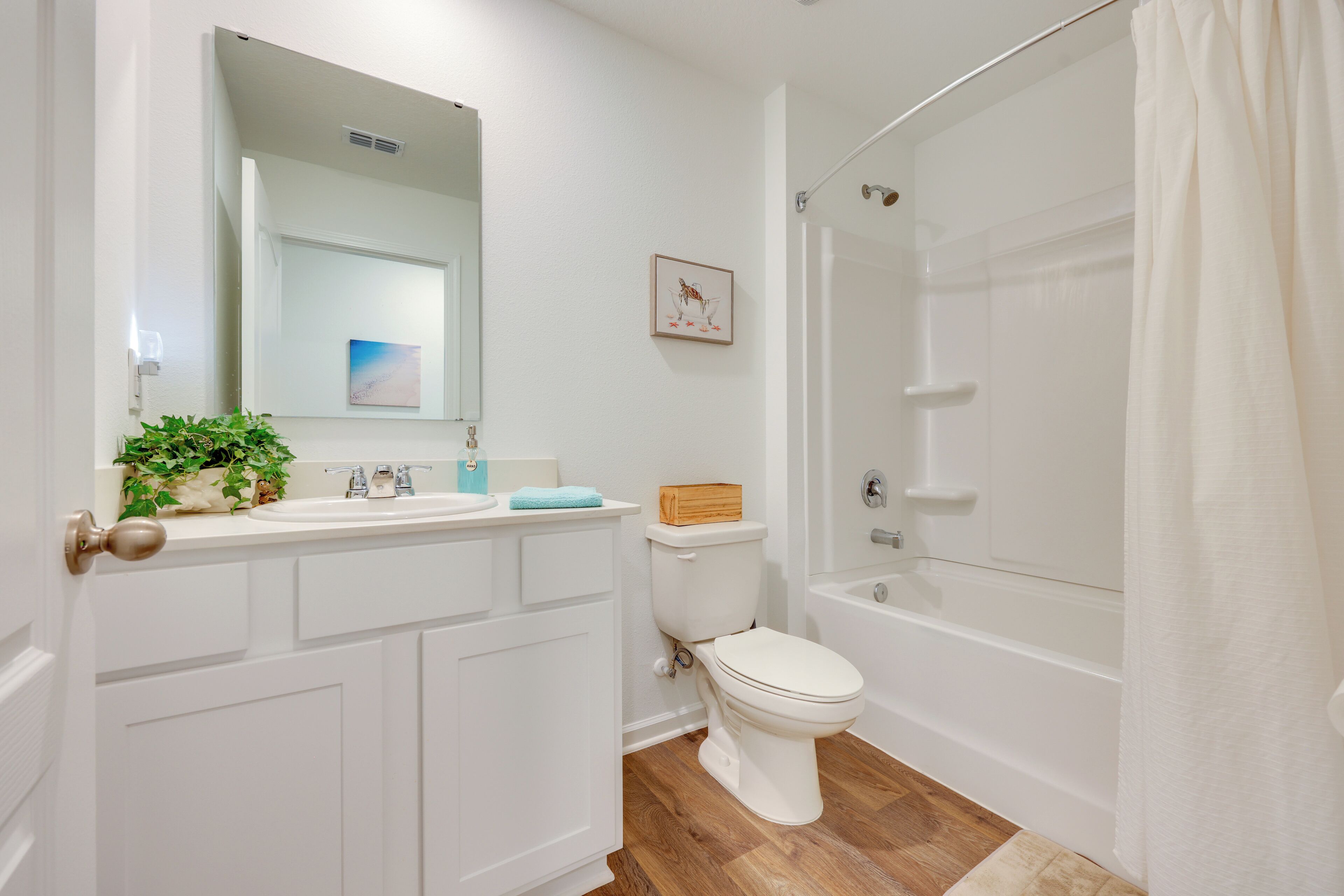A bathroom with a white sink, toilet, and bathtub.
