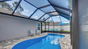 An indoor swimming pool with a clear view of the sky through a glass roof, surrounded by stone flooring and a few lounge chairs. - Home Near Flagler Beach, Daytona, Parks & More! (Palm Coast)