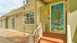 A motel with a wooden porch, a green door with a window, and a small garden area with pebbles. - < 1 Mi to Bull Shoals Lake: 'the Blue Quill' (Bull Shoals)