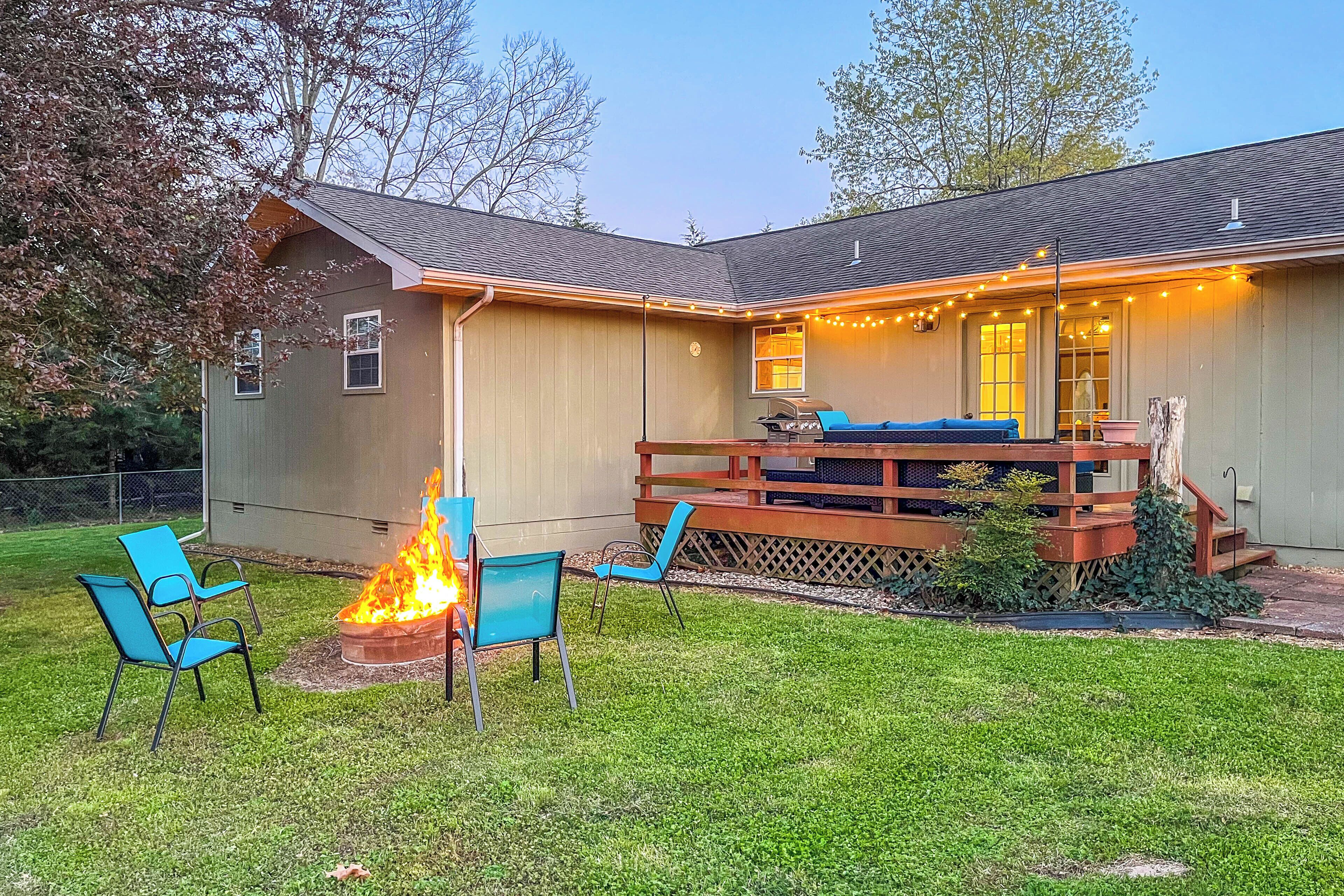 A house with a deck, a fire pit, and outdoor seating.