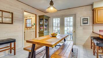 Un interior de madera con una mesa de comedor, bancos y una zona de cocina.