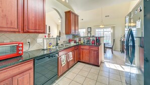 A spacious kitchen with wooden cabinets, a built-in dishwasher, and a red toaster. - 6 Mi to Charlotte Motor Speedway: Home w/ Fire Pit (Concord)