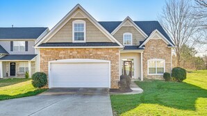 A two-story house with a stone facade, a garage, and a well-maintained lawn. - 6 Mi to Charlotte Motor Speedway: Home w/ Fire Pit (Concord)
