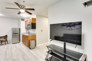 A modern kitchen with a refrigerator, microwave, and wooden cabinets. - Half-mi to Oakland City Golf Club: Sleek Apartment (Oakland City)