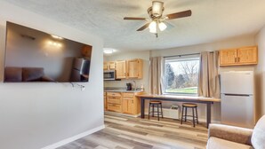 A modern kitchen with wooden cabinets, a built-in stove, and a window with curtains. - Golf, Shop, Tour & More: Oakland City Apartment (Oakland City)