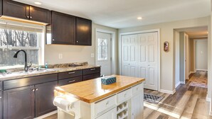 A modern kitchen with dark cabinets, a wooden countertop, and a built-in wine cooler. - Golf Course Views: Oakland City Retreat (Oakland City)
