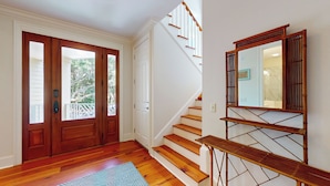 Un escalier en bois, avec des murs blancs et une main courante en bois.