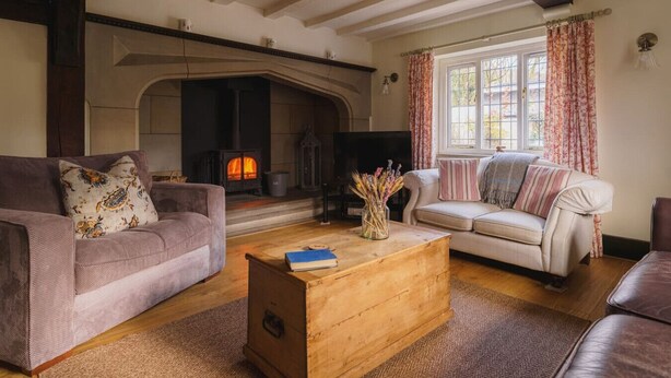 Una sala de estar acogedora con chimenea, dos sofás y una mesa de centro de madera.