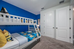 A bunk bed with a blue wall and a white door. - New Construction - Cozy Home & Playroom (Davenport)