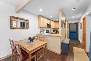 Cocina pequeña con armarios de madera, microondas y pileta.