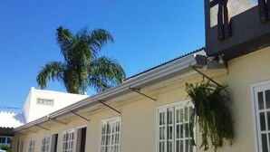 A building with a flat roof, multiple windows, and a door. - Pousada da Pedra do Mar (Matinhos)
