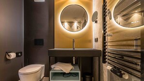 Un baño moderno con inodoro, lavamanos y toallero.